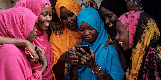 Young Somali women look at a smartphone at Dadaab refugee complex, in northeast Kenya, on April 16. (Yasuyoshi Chiba/AFP/Getty Images)