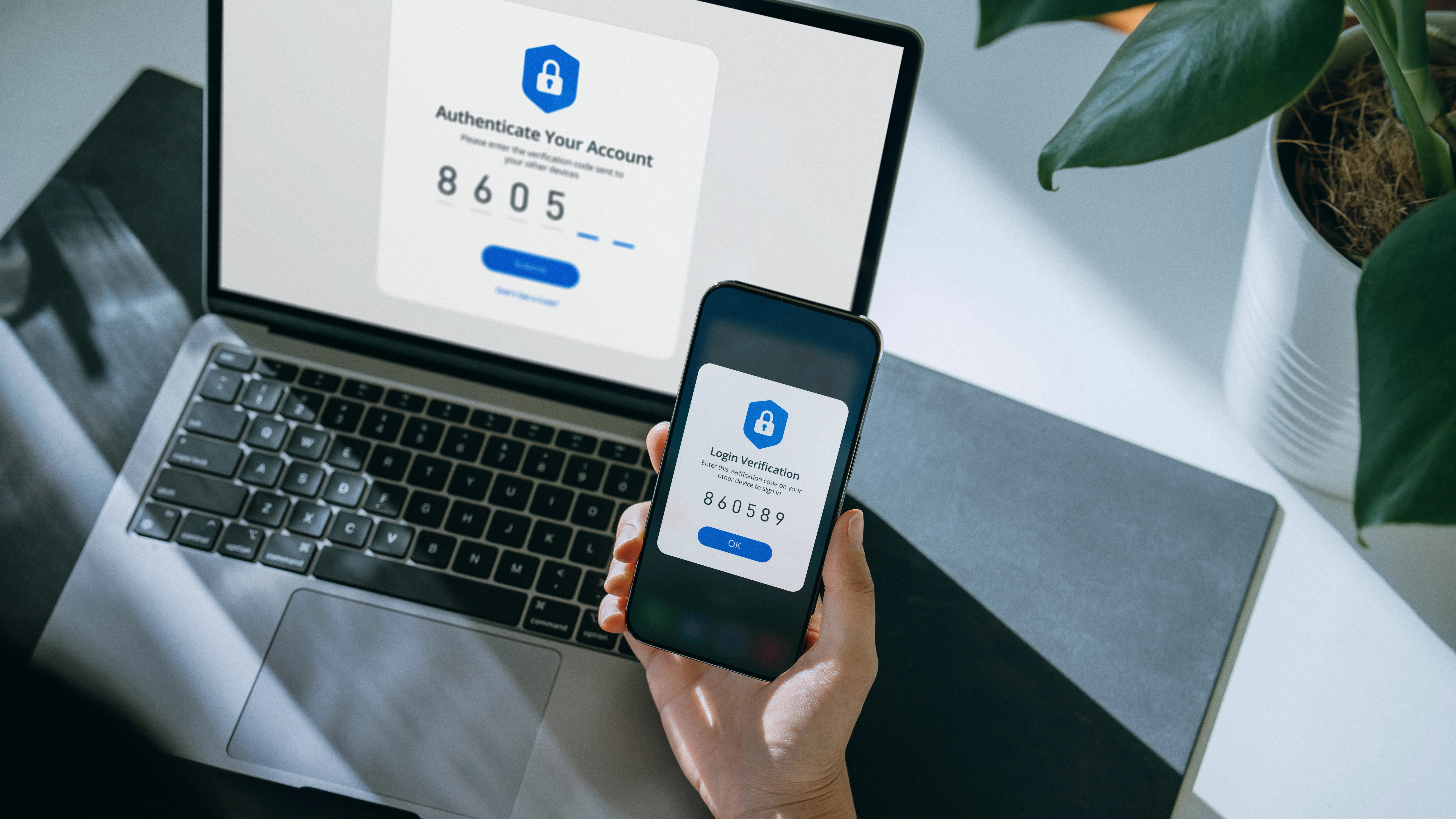 An image of Cropped hand of woman using mobile device with Two-Factor Authentication security while logging in securely to her laptop.
