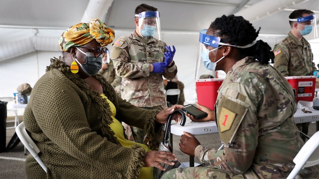 Photo shows an Army soldier preparing to immunize a woman for COVID-19 at a state-run vaccination site at Miami Dade College North Campus in North Miami, Florida, in March 2021.