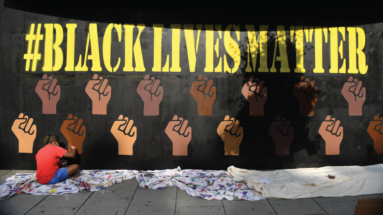 A painter creates a mural on the boarded-up windows of the Park at 14th nightclub in Washington, D.C., on June 6. (Toni L. Sandys/The Washington Post via Getty Images)