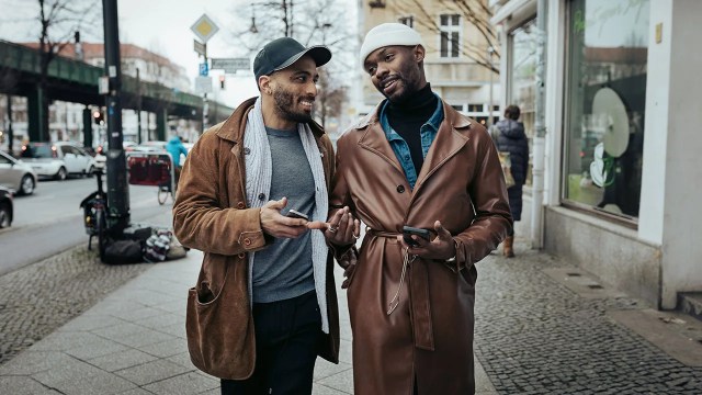 A gay couple walking down the street after meeting each other on a dating app, on their way to eat some food.