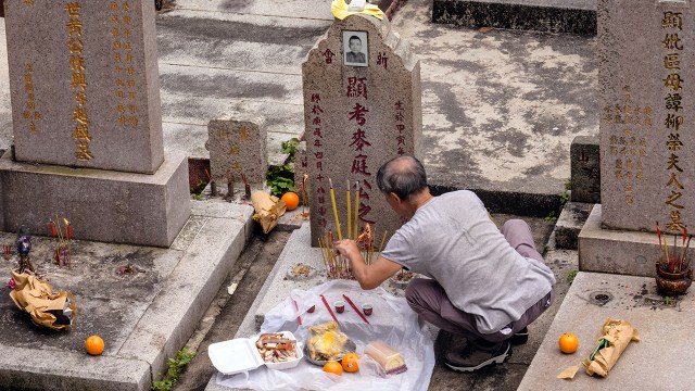 A man burns joss sticks in a cemetery during the Ching Ming Festival, or Grave Sweeping Day, in Hong Kong. 