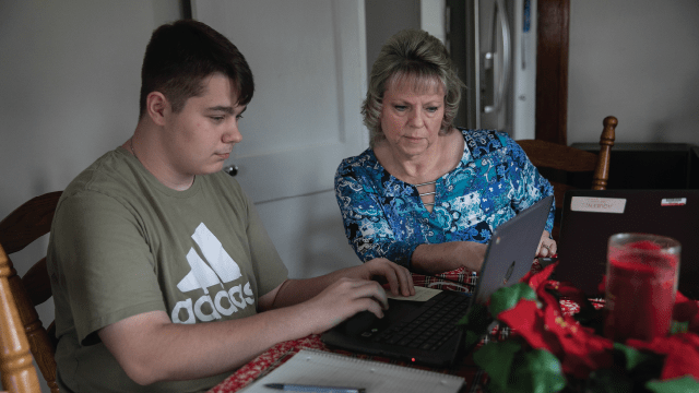 Alisa Queen looks at the work her son Wyatt is doing while homeschooling in Coolville, Ohio, in 2023. (Maddie McGarvey/For The Washington Post via Getty Images)