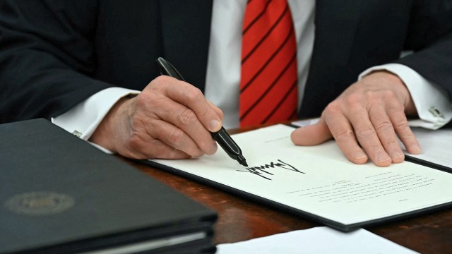 President Donald Trump signs an executive order in the Oval Office on Feb. 10, 2025. (Andrew Caballero-Reynolds/AFP via Getty Images)