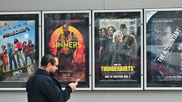A man walks past several movie posters at an AMC Theatre in Montebello, California, on May 5, 2025. (Frederic J. Brown/AFP via Getty Images)